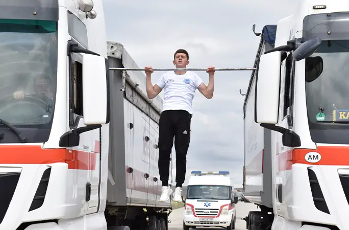 Video - Armenian teen breaks record performing pull ups between moving trucks